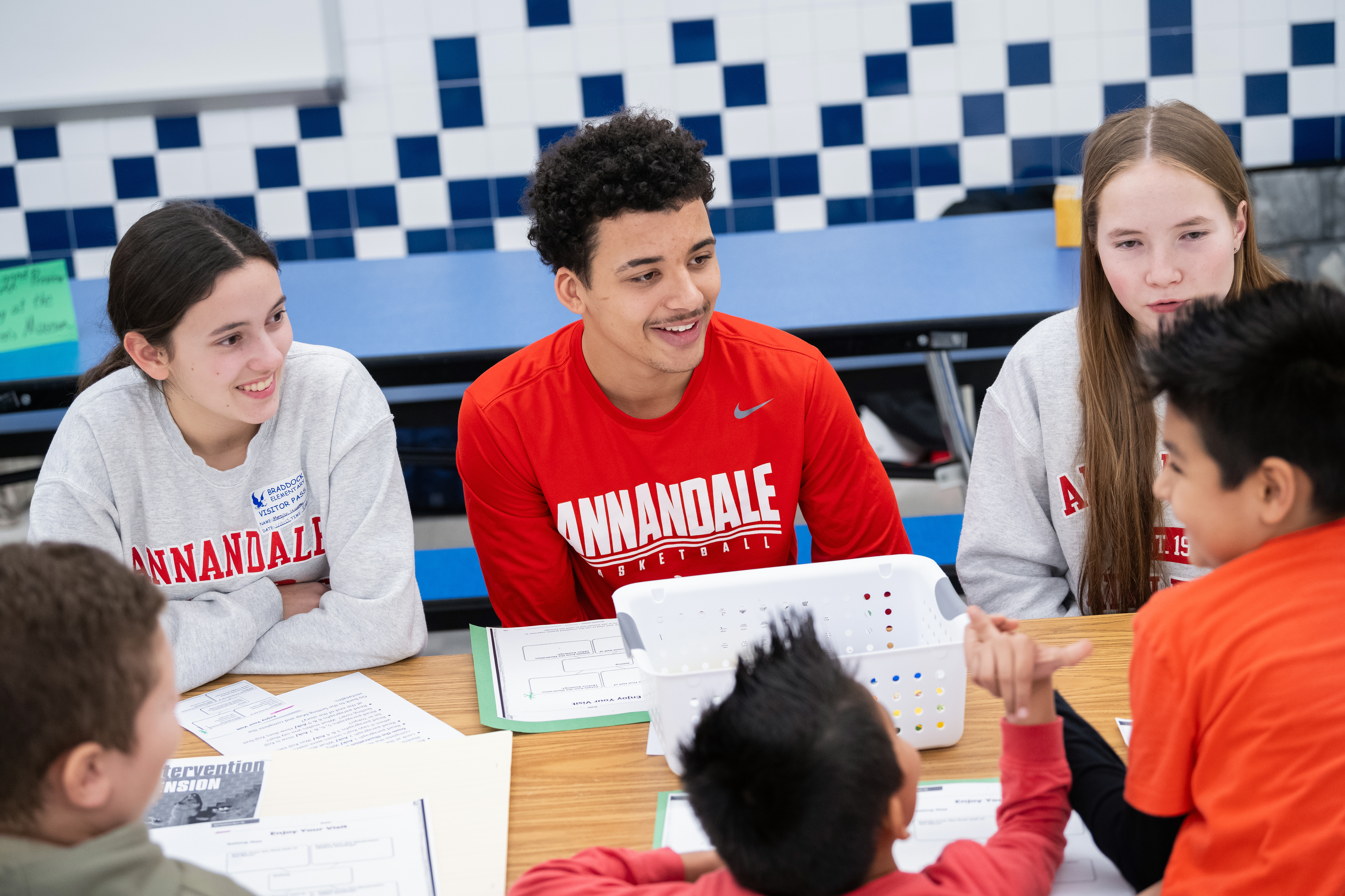 Annandale High School and Braddock Elementary School students smile as they work together on a reading lesson.