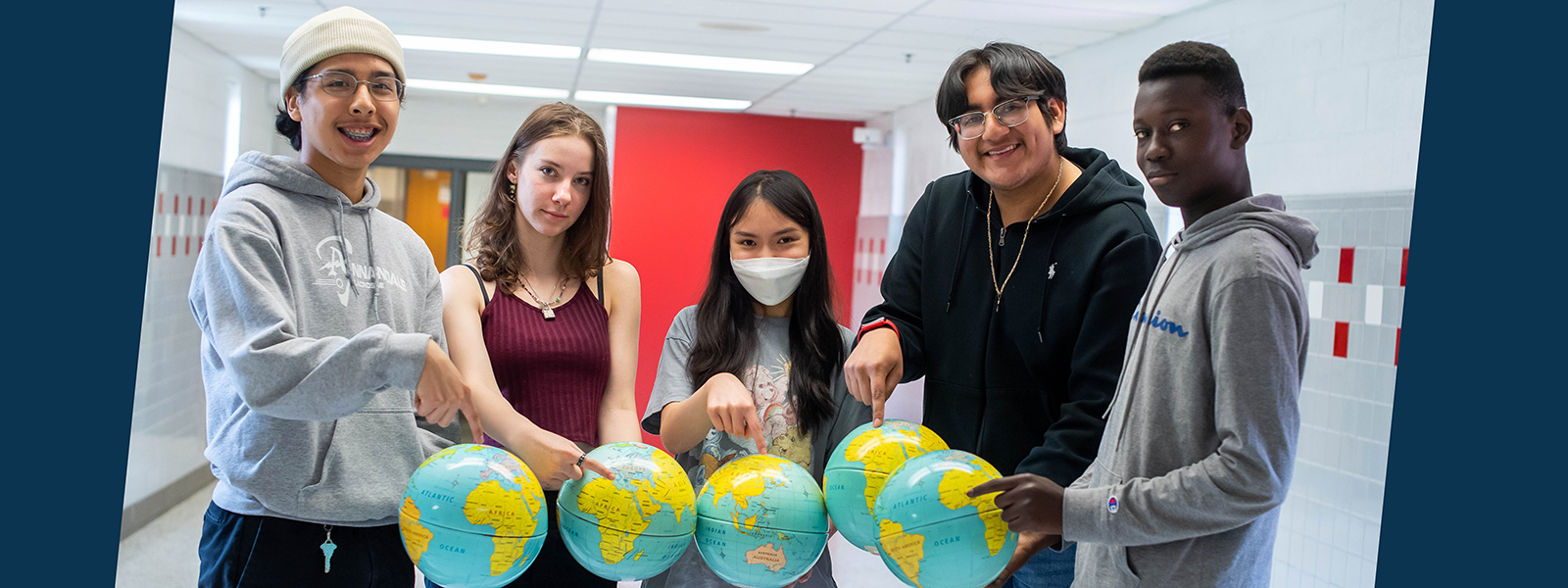 Annandale High School students point out their summer abroad destinations on globes.