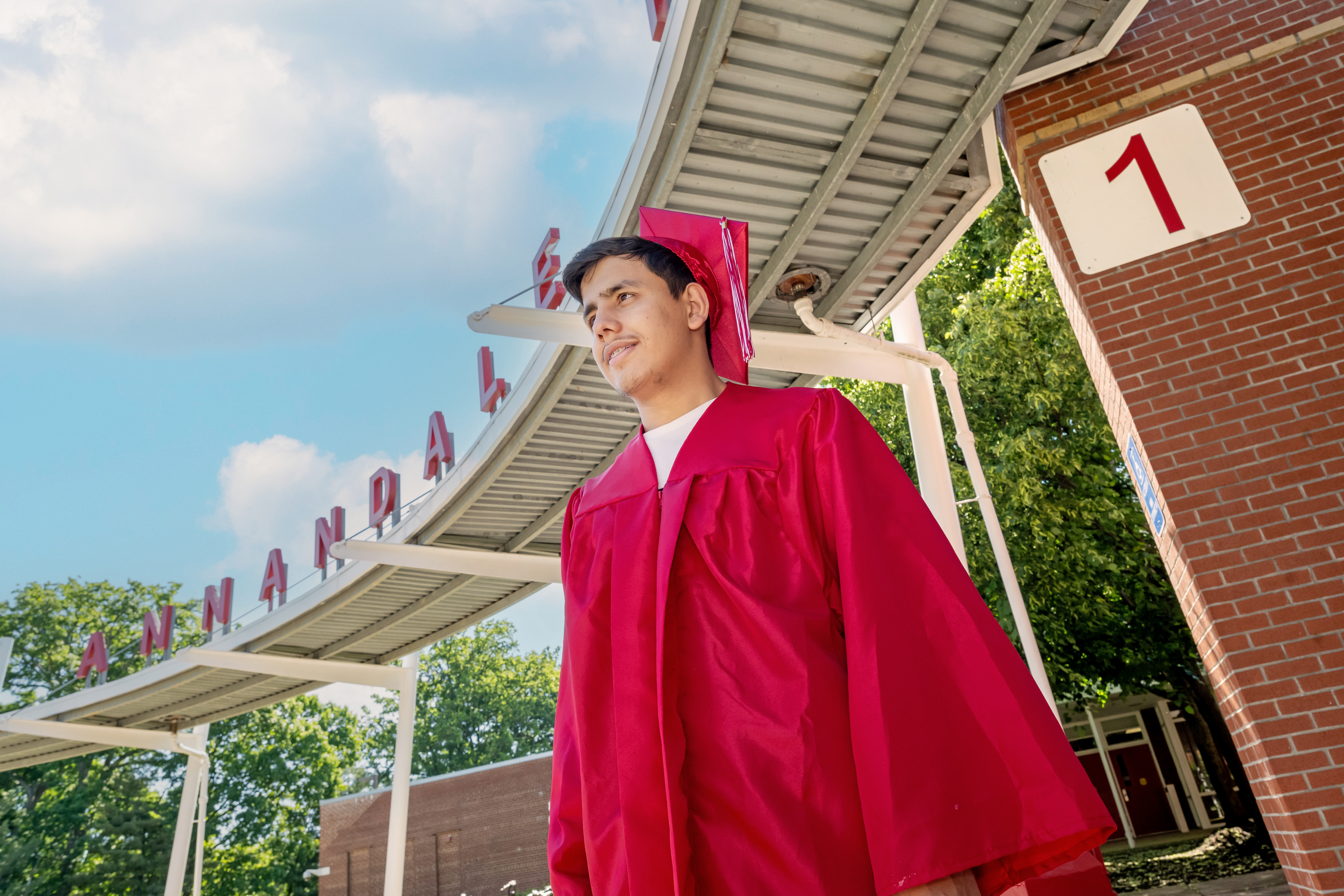 Annandale senior Samiullah Luddin, wearing a cap and gown in front of his school, plans to study business administration at Northern Virginia Community College in the fall.